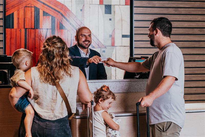 Family of four checking in at a hotel front desk